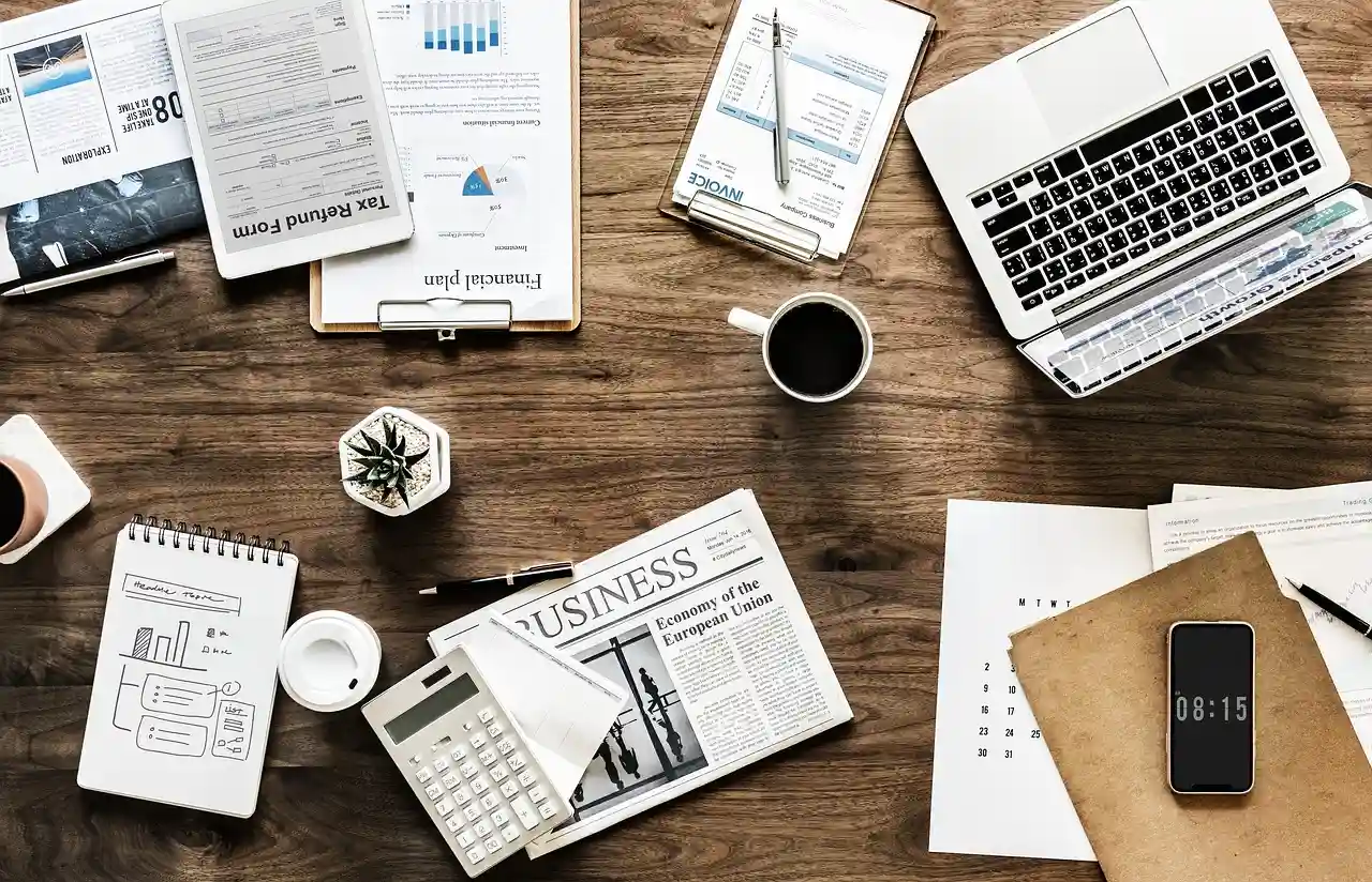 Vue en plongée d'un bureau de travail avec documents d'analyse financière et ordinateur